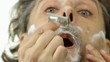 shaving with safety razor and shaving cream over white