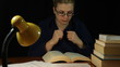 Scared woman in bathrobe reading book at night