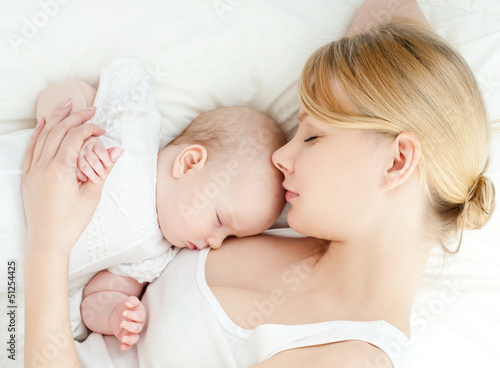 Photo: Young mother and her baby, sleeping in bed Young mother and her baby, sleeping in bed