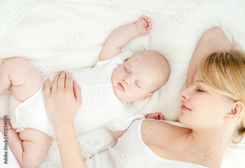 Photo: Young mother and her baby, sleeping in bed Young mother and her baby, sleeping in bed