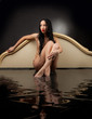 Girl with wet clothes sitting in the black water 