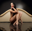 Girl with wet clothes sitting in the black water 
