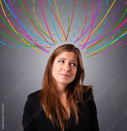 Photo: Young girl thinking with colorful abstract lines overhead Young girl thinking with colorful abstract lines overhead