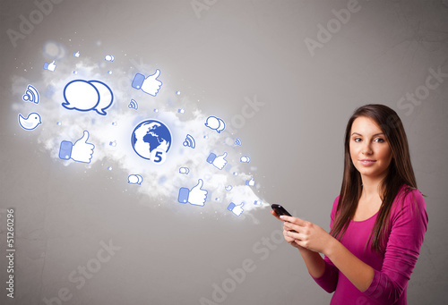 Photo: Pretty young girl holding a phone with social media icons Pretty young girl holding a phone with social media icons