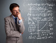 Handsome school boy thinking about complex mathematical signs