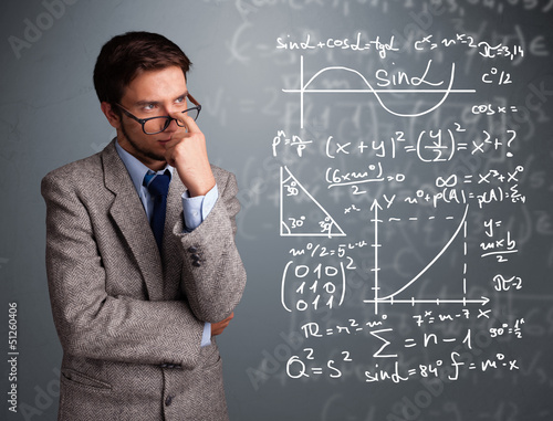 Photo: Handsome school boy thinking about complex mathematical signs Handsome school boy thinking about complex mathematical signs