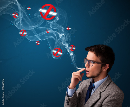 Photo: Attractive man smoking dangerous cigarette with no smoking signs Attractive man smoking dangerous cigarette with no smoking signs