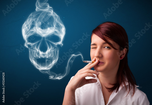 Photo: Young woman smoking dangerous cigarette with toxic skull smoke Young woman smoking dangerous cigarette with toxic skull smoke