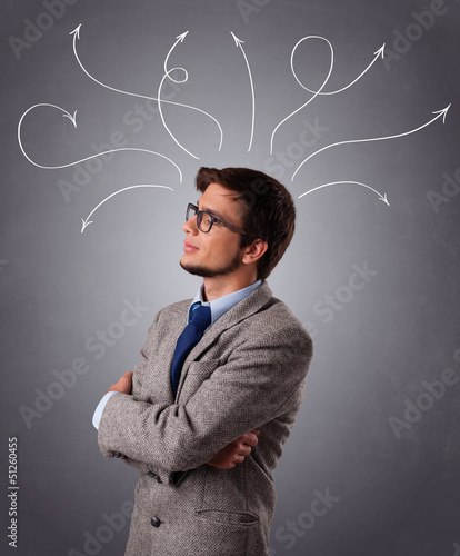 Photo: Young man thinking with arrows overhead Young man thinking with arrows overhead