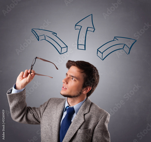 Photo: Handsome man thinking with arrows overhead Handsome man thinking with arrows overhead