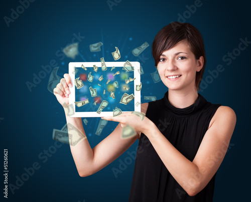 Photo: young woman holding tablet with money young woman holding tablet with money