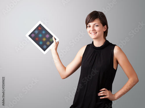 Photo: woman holding modern tablet with colorful icons woman holding modern tablet with colorful icons