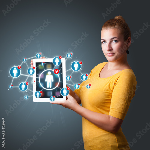 Photo: young woman holding tablet with social network icons young woman holding tablet with social network icons