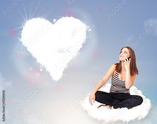 Photo: Beautiful lovely woman sitting on cloud with heart Beautiful lovely woman sitting on cloud with heart