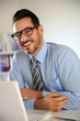 Cheerful businessman working on laptop computer
