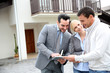 Real-estate-agent showing house plan on digital tablet