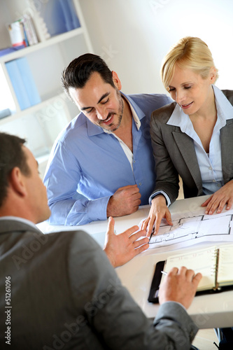 Photo: Couple meeting real-estate agent to buy property Couple meeting real-estate agent to buy property