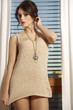 Young slim sexy woman in brown sweater against the window