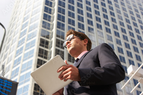Photo: Businessman Working On Tablet Computer Outside Office Businessman Working On Tablet Computer Outside Office