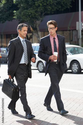 Photo: Two Businessman Chatting Whilst Crossing Street Two Businessman Chatting Whilst Crossing Street