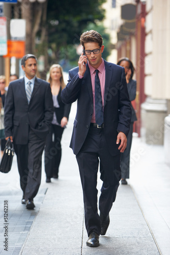 Photo: Businessman Outside Office On Mobile Phone Businessman Outside Office On Mobile Phone