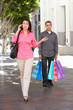 Foto: Fed Up Man Carrying Partners Shopping Bags On City Street Fed Up Man Carrying Partners Shopping Bags On City Street