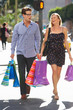 Foto: Couple Carrying Shopping Bags On City Street Couple Carrying Shopping Bags On City Street