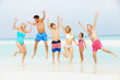 Multi Generation Family Having Fun In Sea On Beach Holiday