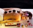 Foto: Woman getting stones spa procedures. Woman getting stones spa procedures.
