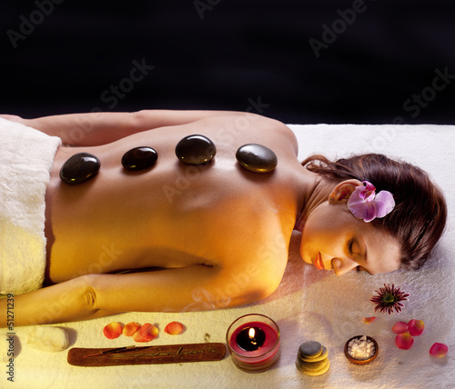 Photo: Woman getting stones spa procedures. Woman getting stones spa procedures.