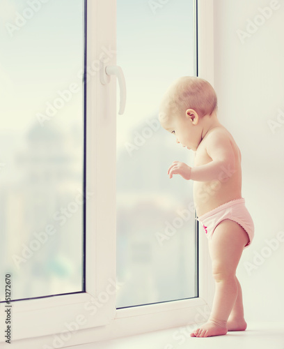 Photo: baby girl looking out the window longing, sadness, and waiting baby girl looking out the window longing, sadness, and waiting