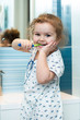 Child girl brushing teeth in bathroom