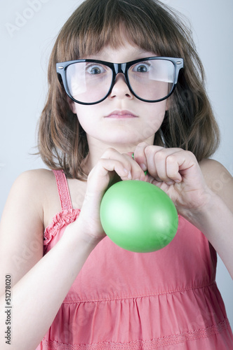 Photo: funny girl with herd sunglasses blowing a balloon funny girl with herd sunglasses blowing a balloon
