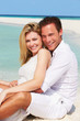Romantic Couple Sitting On Beautiful Tropical Beach