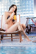 Pretty young woman relaxing by the pool