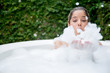 Happy woman taking a bubble bath