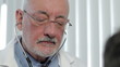 Close up of doctor's face checking a patient's heart rate