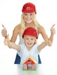 Foto: Two girls with helmet shows thumbs up for building a house Two girls with helmet shows thumbs up for building a house