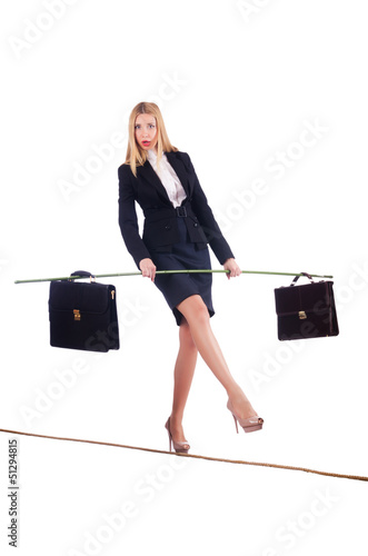 Photo: Businesswoman walking on tight rope isolated Businesswoman walking on tight rope isolated