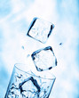 Ice cubes falling into a water glass