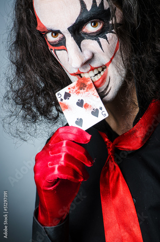 Photo: Evil clown with cards in dark room Evil clown with cards in dark room