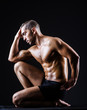 Muscular man in dark studio