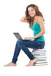 Foto: Student with netbook sitting on books Student with netbook sitting on books