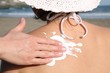 applying sun creme on the shoulder of a woman
