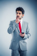 young businessman thinking  what to type next to his cell phone