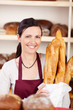 lächelnde verkäuferin mit baguettes