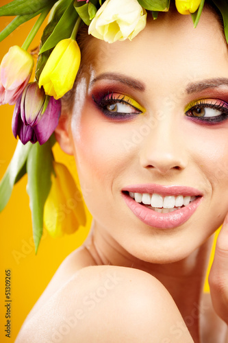 Photo: woman portrait with wreath from flowers on head over spring bac woman portrait with wreath from flowers on head over spring bac