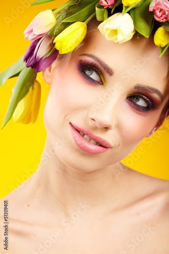 Photo: woman portrait with wreath from flowers on head over spring bac woman portrait with wreath from flowers on head over spring bac