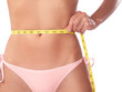 Photo: Young slim woman measuring her waist with a tape Young slim woman measuring her waist with a tape