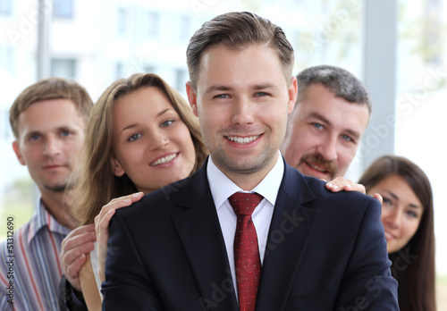 Photo: happy young male business leader standing in front of his team happy young male business leader standing in front of his team